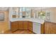 Open kitchen with wooden cabinets, white countertops, and stainless steel dishwasher at 402 Bridewell Ct, Cary, NC 27518