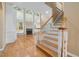 Sun-filled living room featuring a fireplace, large windows, and hardwood floors with stairway at 402 Bridewell Ct, Cary, NC 27518