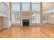 Spacious living room with fireplace, built-in shelving, and large windows at 402 Bridewell Ct, Cary, NC 27518