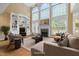 Spacious living room with tall windows, a fireplace, built-in shelving and hardwood floors at 402 Bridewell Ct, Cary, NC 27518