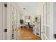 Bright office space featuring hardwood floors, a modern desk setup, and natural light through French doors at 402 Bridewell Ct, Cary, NC 27518