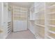 Spacious walk-in closet featuring custom shelving, drawers, and pull-out baskets at 402 Bridewell Ct, Cary, NC 27518