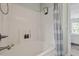 Bright bathroom with a shower and tub combo featuring neutral wall color and a patterned gray and white shower curtain at 404 Ascott Way, Durham, NC 27713