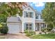 Charming two-story home with light colored siding, blue shutters, attached garage and mature landscaping at 404 Ascott Way, Durham, NC 27713