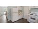 The kitchen features white appliances, cabinets, and hardwood floors at 404 Ascott Way, Durham, NC 27713