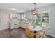 Sunlit kitchen features white cabinets, dining area, and stainless steel appliances at 404 Ascott Way, Durham, NC 27713