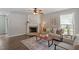 Cozy living room featuring a fireplace, neutral colored furniture, ceiling fan and decorative rug on a wood floor at 404 Ascott Way, Durham, NC 27713