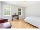 Bright bedroom features two windows, wood floors, and a neutral color scheme for a peaceful retreat at 404 Sw Maynard Rd, Cary, NC 27511