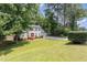 Charming two-story home with a red door and a spacious front yard with mature trees providing shade at 404 Sw Maynard Rd, Cary, NC 27511