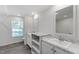 Modern bathroom featuring marble countertops, dual sinks, white cabinets, and wood laminate flooring at 41 Andrea Ct, Sanford, NC 27332