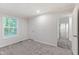 Bright bedroom featuring gray carpet, a window, and an open doorway to the hallway at 41 Andrea Ct, Sanford, NC 27332