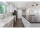 Stylish kitchen with white cabinets, sleek stainless steel appliances, a dark island, and durable gray laminate flooring at 41 Andrea Ct, Sanford, NC 27332
