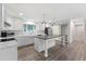 Bright kitchen with white cabinets, center island, stainless appliances, and wood laminate flooring at 41 Andrea Ct, Sanford, NC 27332