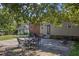 A patio in backyard with outdoor seating, shaded by trees and surrounded by greenery at 412 Coggeshall St, Oxford, NC 27565