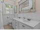 Bathroom with tiled floors, white vanity with double sinks and a large beveled mirror at 412 Coggeshall St, Oxford, NC 27565