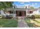 Charming brick home featuring a welcoming front porch with white railings and an American flag at 412 Coggeshall St, Oxford, NC 27565