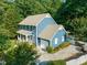 Aerial view of blue two story home showcasing pristine landscaping, garage, and spacious driveway at 4151 Deep Wood Cir, Durham, NC 27707