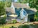 Aerial view of a beautiful blue home with a backyard deck and patio, nestled among mature trees at 4151 Deep Wood Cir, Durham, NC 27707