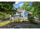 Well-maintained backyard with deck, patio, mature trees, lush greenery, and a cozy fire pit area at 4151 Deep Wood Cir, Durham, NC 27707