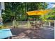Spacious wooden deck with outdoor furniture, a yellow umbrella, and a view of the well-maintained backyard at 4151 Deep Wood Cir, Durham, NC 27707