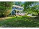 Charming two-story home with a well-manicured lawn, inviting front porch, and classic blue siding at 4151 Deep Wood Cir, Durham, NC 27707