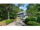 Two story blue home with mature trees, manicured bushes, spacious driveway, and attached garage at 4151 Deep Wood Cir, Durham, NC 27707