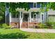 Charming blue home featuring a welcoming front porch with brick stairs and manicured landscaping at 4151 Deep Wood Cir, Durham, NC 27707