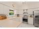 Well-lit kitchen features white cabinets, stainless steel appliances, and a large window at 4151 Deep Wood Cir, Durham, NC 27707