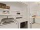 Modern laundry room featuring washer and dryer with storage shelves above at 4151 Deep Wood Cir, Durham, NC 27707