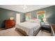 Well-lit bedroom featuring a plush bed, wooden furniture, and windows with blinds at 4151 Deep Wood Cir, Durham, NC 27707