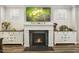 Elegant fireplace with white mantle, TV above, and decorative side cabinets at 465 Gianna Dr, Clayton, NC 27527