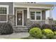 Close-up of front door with stone accents, porch, and landscaped bushes at 465 Gianna Dr, Clayton, NC 27527