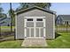 Well-maintained shed with double doors, offering additional storage space in a fenced backyard at 465 Gianna Dr, Clayton, NC 27527