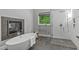Luxurious bathroom features a soaking tub, walk-in shower, and heated towel rack near a green view window at 4905 Ivercroft Pl, Fuquay Varina, NC 27526