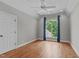 Bedroom with hardwood floors, arched window with blue curtains and ceiling fan at 4905 Ivercroft Pl, Fuquay Varina, NC 27526