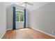 Bedroom with hardwood floors, natural light and arched window with blue curtains at 4905 Ivercroft Pl, Fuquay Varina, NC 27526