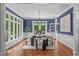 Bright dining room featuring hardwood floors, blue walls, and large windows with natural light at 4905 Ivercroft Pl, Fuquay Varina, NC 27526