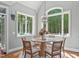 Bright dining room with large arched window, wood floors, decorative chandelier, and ample seating at 4905 Ivercroft Pl, Fuquay Varina, NC 27526