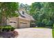 A brick home features a spacious three-car garage and driveway, set against a lush, tree-lined backdrop at 4905 Ivercroft Pl, Fuquay Varina, NC 27526