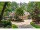 Brick home with a two-car garage surrounded by mature trees and landscaping at 4905 Ivercroft Pl, Fuquay Varina, NC 27526