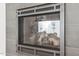 Close up of a modern fireplace with decorative tile surround and realistic log display at 4905 Ivercroft Pl, Fuquay Varina, NC 27526