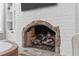 Close up of stone fireplace with gas logs, custom stonework, and a white brick mantel at 4905 Ivercroft Pl, Fuquay Varina, NC 27526