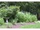 A tranquil garden setting with lush foliage and a bird bath at 4905 Ivercroft Pl, Fuquay Varina, NC 27526
