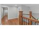 Hallway upstairs showing hardwood flooring, wooden banisters and access to multiple rooms at 4905 Ivercroft Pl, Fuquay Varina, NC 27526