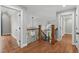 Upstairs hallway boasting hardwood flooring, iron and wood banisters, and architectural design details at 4905 Ivercroft Pl, Fuquay Varina, NC 27526