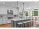 Beautiful white kitchen features a gray island with seating, modern appliances, and lots of counter space at 4905 Ivercroft Pl, Fuquay Varina, NC 27526