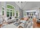 Sun-filled living room with large windows offering serene views and comfortable seating at 4905 Ivercroft Pl, Fuquay Varina, NC 27526