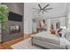 Bright main bedroom featuring a dark stone fireplace, large windows, and exterior doors at 4905 Ivercroft Pl, Fuquay Varina, NC 27526