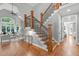 Elegant wooden staircase with wrought iron railing leading to the upper level at 4905 Ivercroft Pl, Fuquay Varina, NC 27526