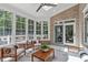 Bright sunroom featuring brick walls, a ceiling fan, lots of windows, and cozy seating arrangements at 4905 Ivercroft Pl, Fuquay Varina, NC 27526